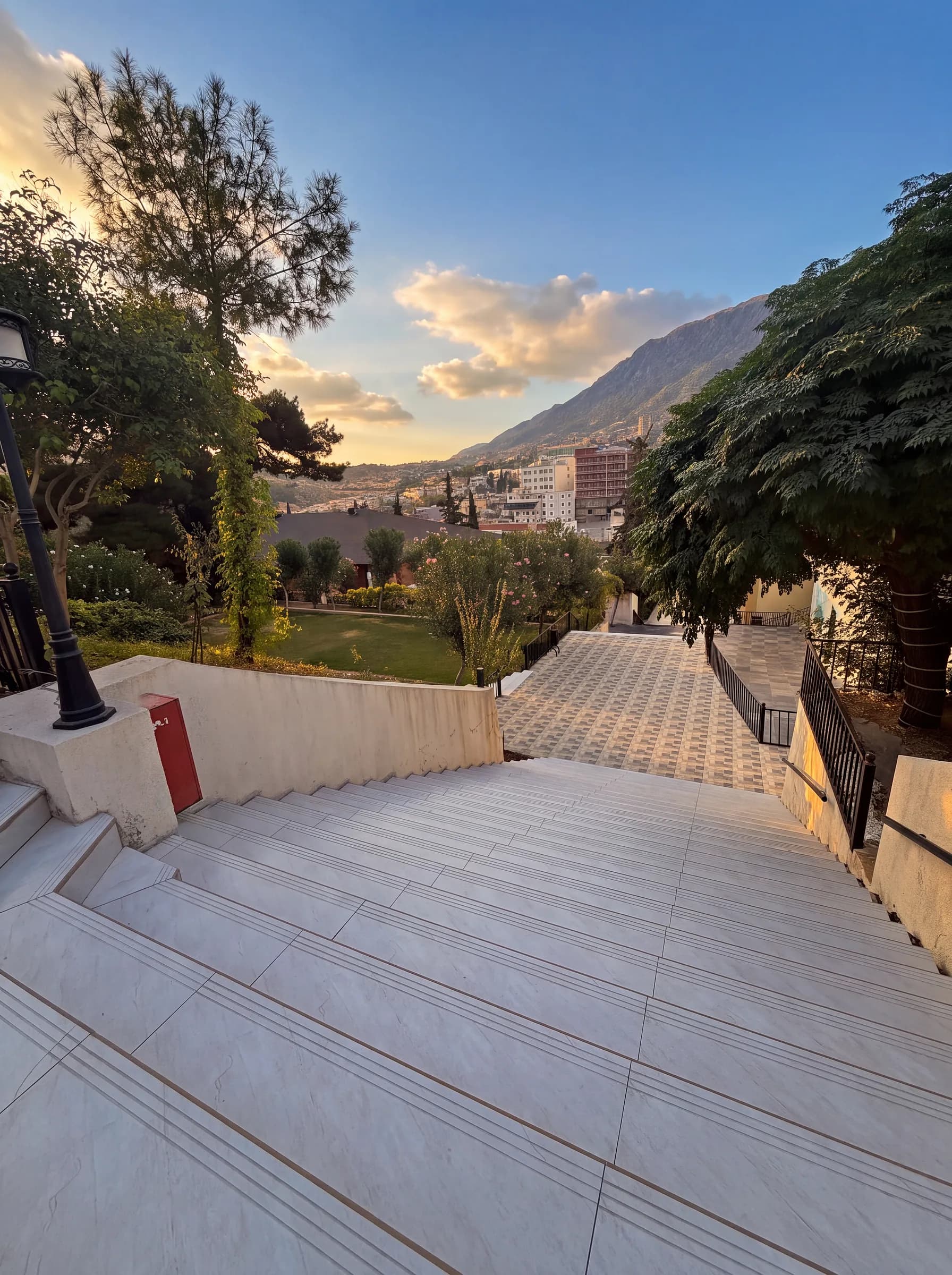 Wide stairs leading down to the garden lawn, with Shaqlawa and Safeen Mountain beyond