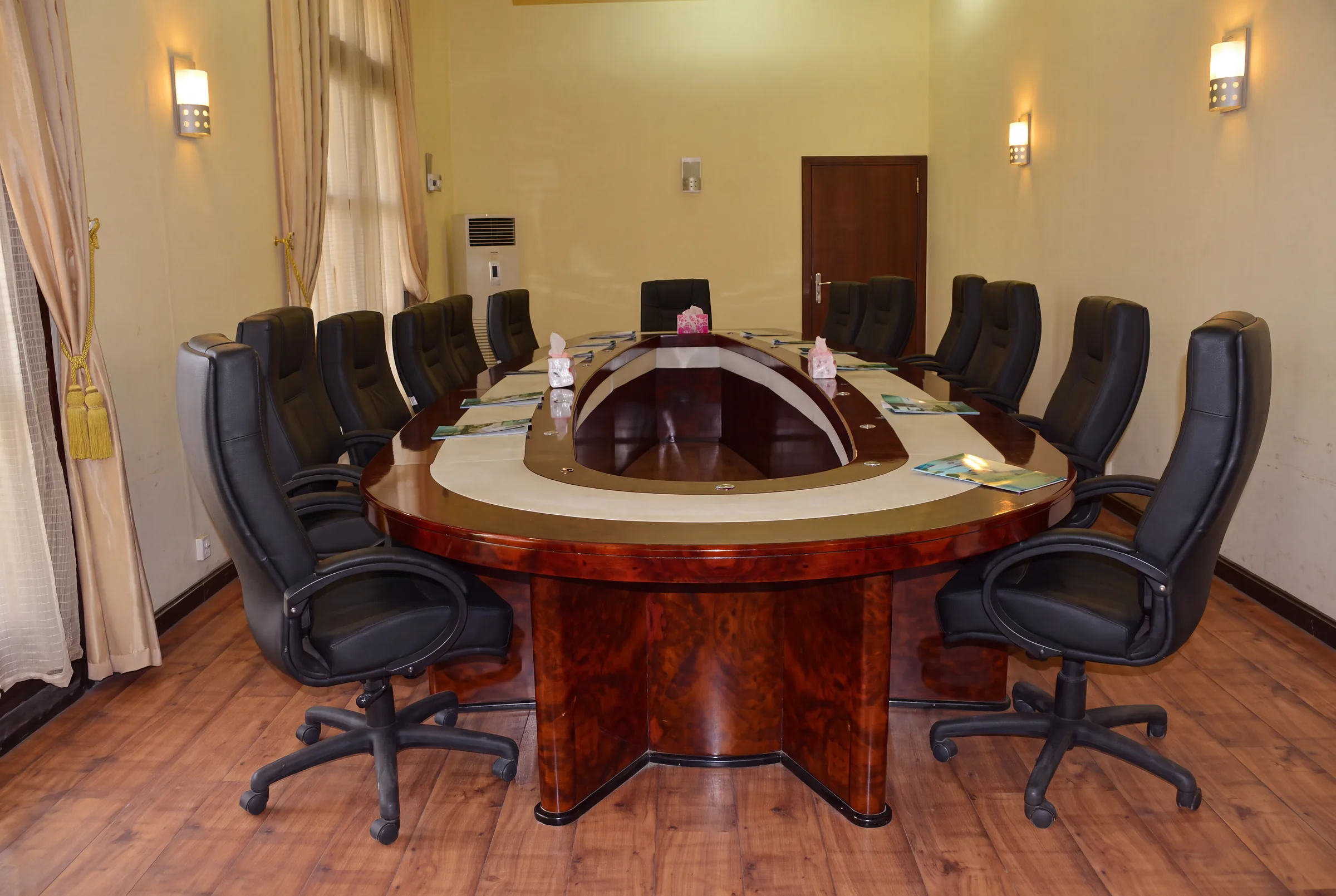 One of our halls, with an oval meeting table and black chairs.