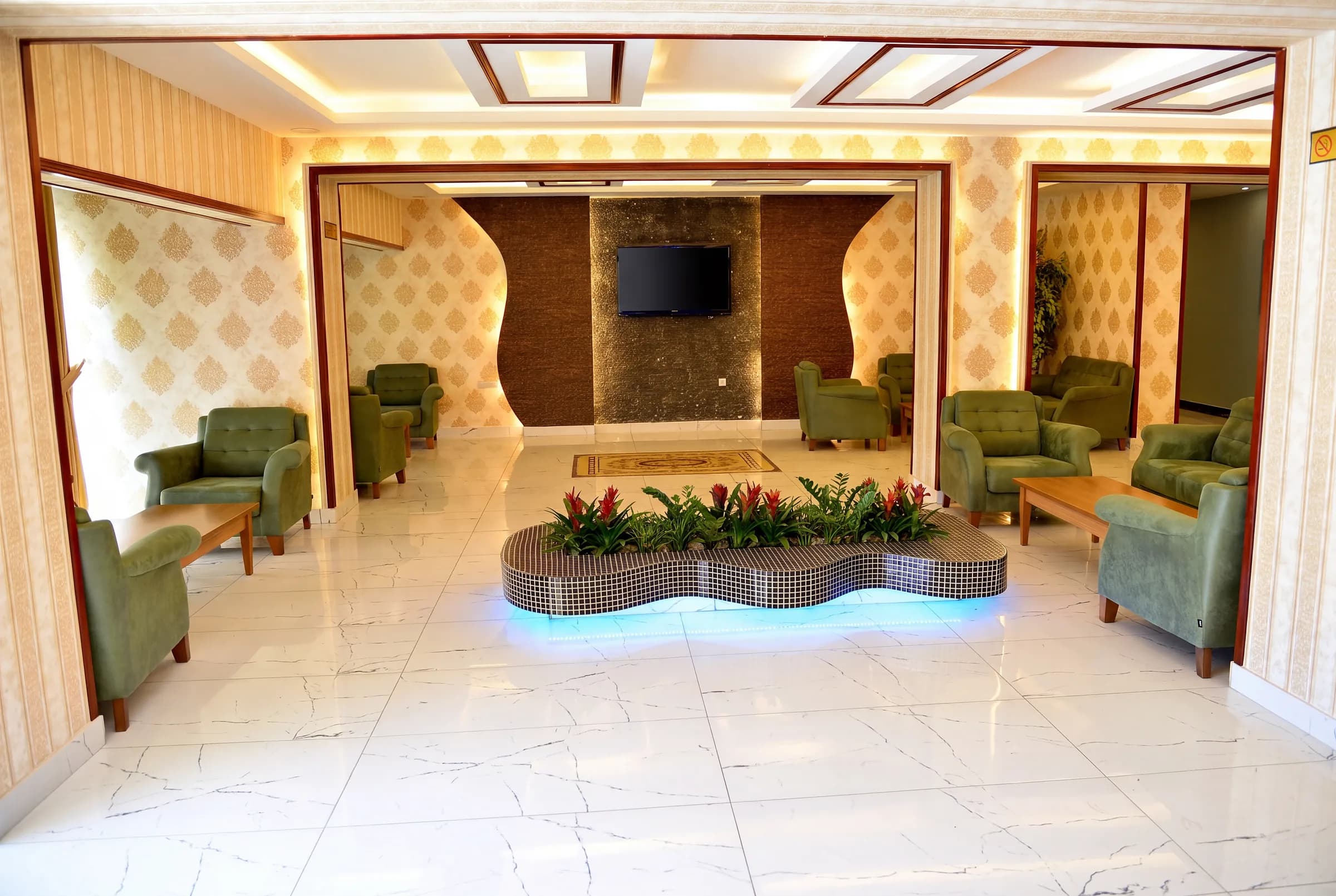 Green armchairs and a planted feature in the hotel lobby lounge.