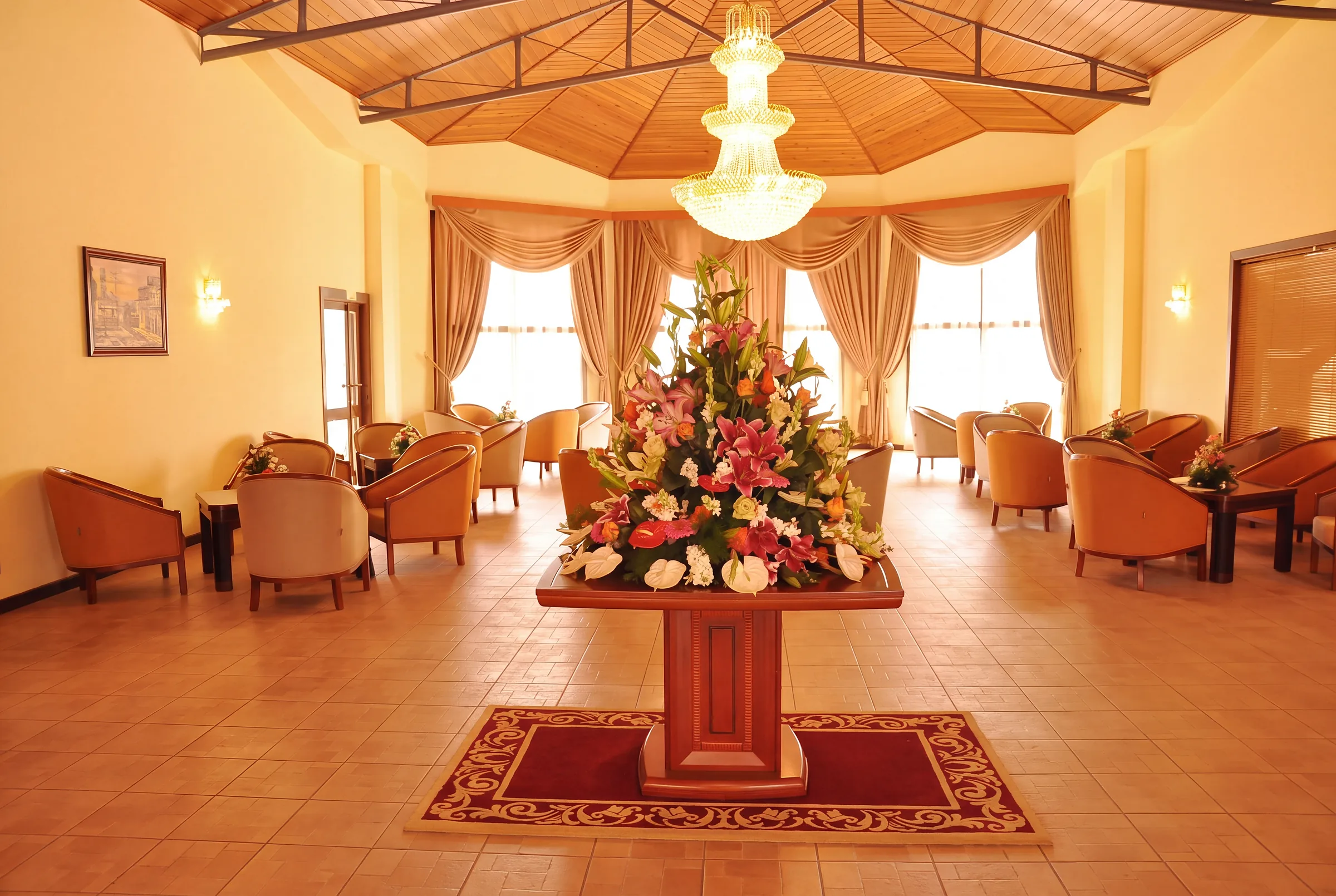 Chandelier, flowers and seating in a lounge in the hotel building.