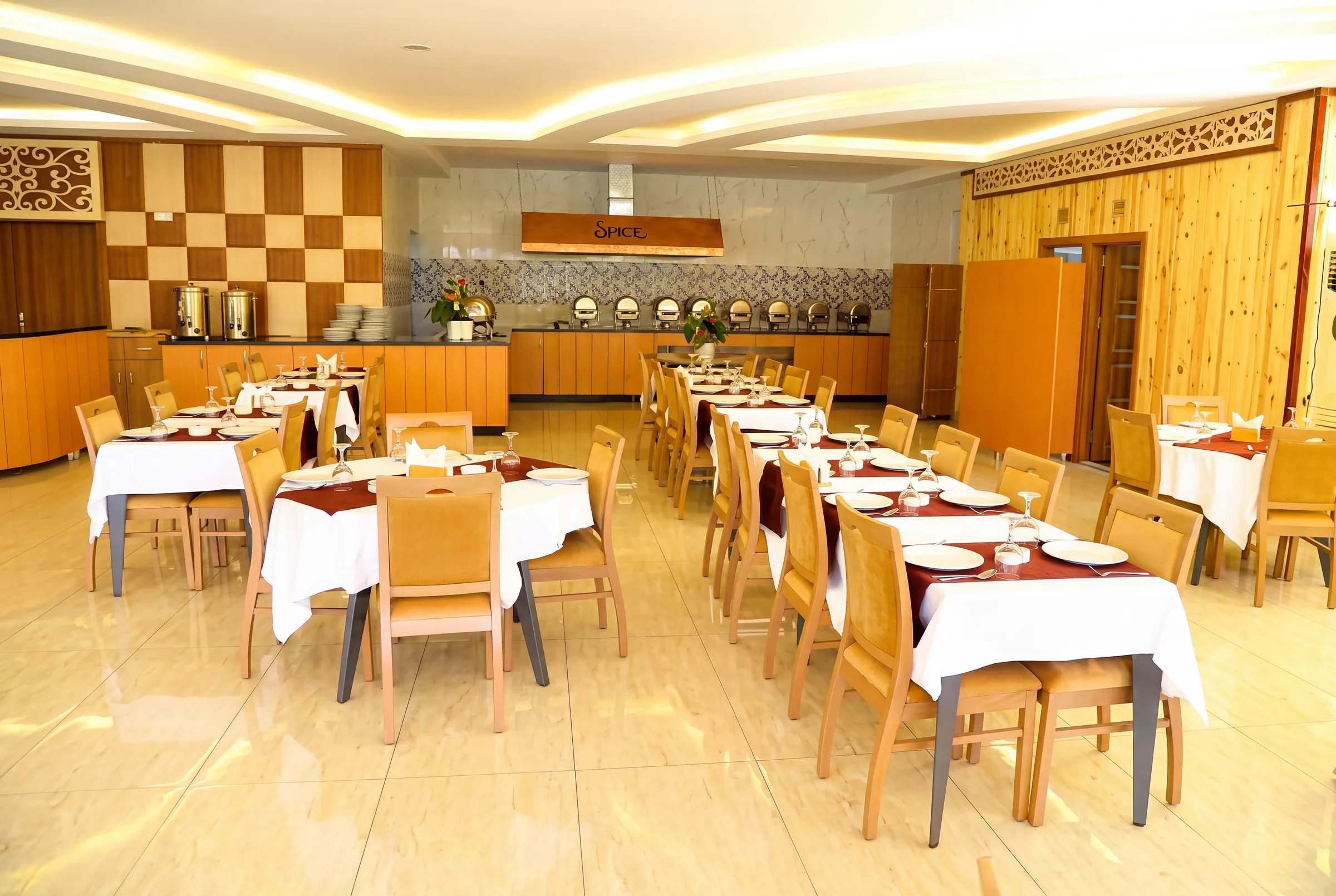 Tables laid for dining beside the restaurant buffet counter.